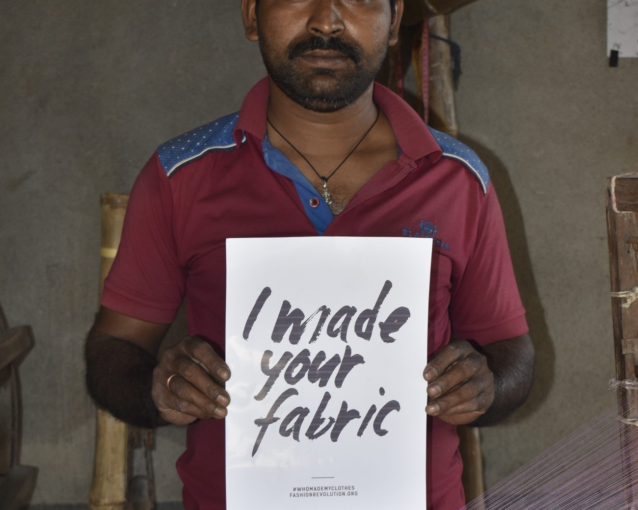 Nayan Guin, a weaver in our dyed khadi cluster, holding a card that reads I made your fabric